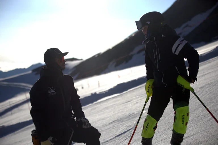 Ski racers warming up with their coach before a training run
